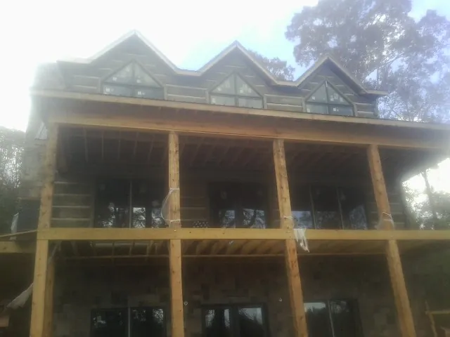 Dormers and porch framing on a large log home under construction — Roof Coating work by our crew in Clontarf